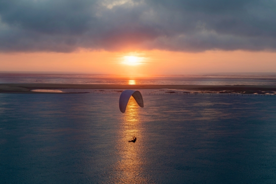 Paraglider über dem Meer bei Sonnenuntergang 