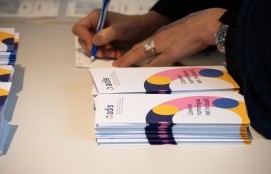  Foto mit Stapeln an ADIS-Flyer